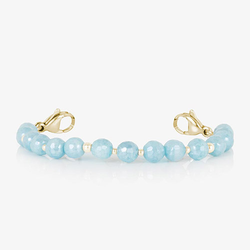 Close-up view of interchangeable bracelet strand featuring pale blue faceted beads and gold accent spacers with gold lobster clasps at each end.