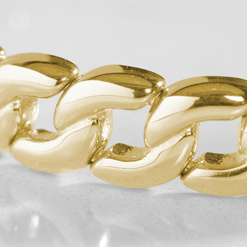 Detailed close-up of chunky gold curb chain links on a women's medical ID bracelet, highlighting the high-shine, luxe finish.