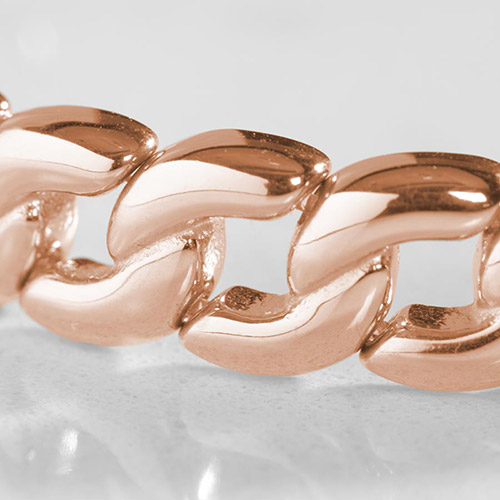 Close-up of high-polish rose gold curb chain links on a women's medical alert bracelet, showcasing smooth, rounded edges and mirror-like shine.