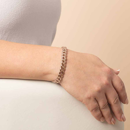 Lauren’s Hope stretch curb chain medical ID bracelet in rose gold on a woman’s wrist, showcasing the bracelet’s classic, high-shine links against a neutral background.