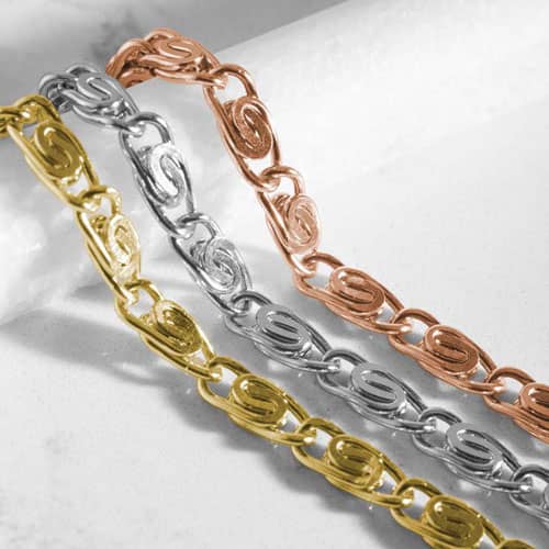 Close-up of silver, gold, and rose gold bracelet chains with decorative swirl links, designed for stylish medical ID jewelry.