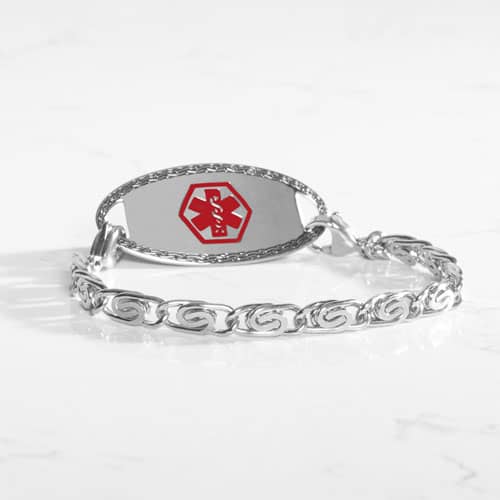 Silver medical ID bracelet with decorative swirl links and red medical emblem, combining elegant jewelry with emergency safety.