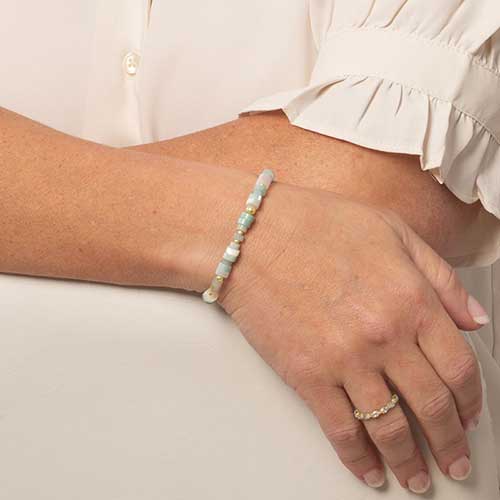 Woman wearing a beaded bracelet of Juniper, Cream and gold.