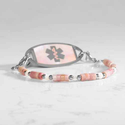 Beaded bracelet featuring Silver tone and Heishi beads in cream and rose on a stretch bracelet, attached to a Silver tone medical ID with a Silver tone medical ID tag with Pink Mother of Pearl id and Silver tone caduceus medical symbol. 