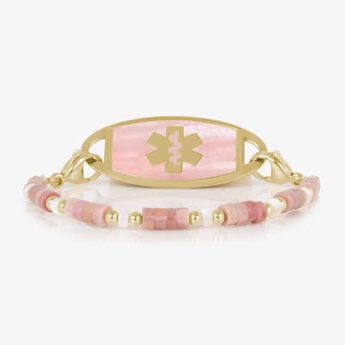 Beaded bracelet featuring gold tone and Heishi beads in cream and rose on a stretch bracelet, attached to a gold tone medical ID with a gold tone medical ID tag with Pink Mother of Pearl id and gold tone caduceus medical symbol. 