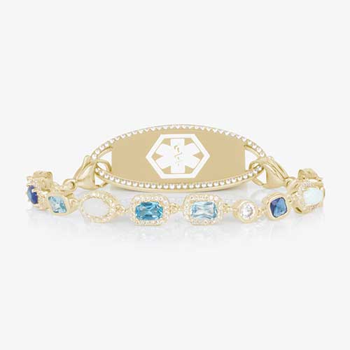 Gold medical ID bracelet with blue gemstone and pearl accents, featuring an engraved medical emblem for elegant everyday safety.