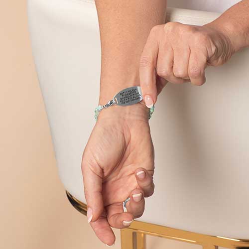 Woman displaying the custom, laser engraved, medical information on the back of her medical ID tag.