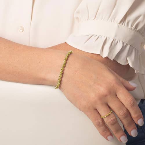 Woman wearing the Facet Gold interchangeable bracelet featuring polished gold-tone faceted links with a modern, elegant look.