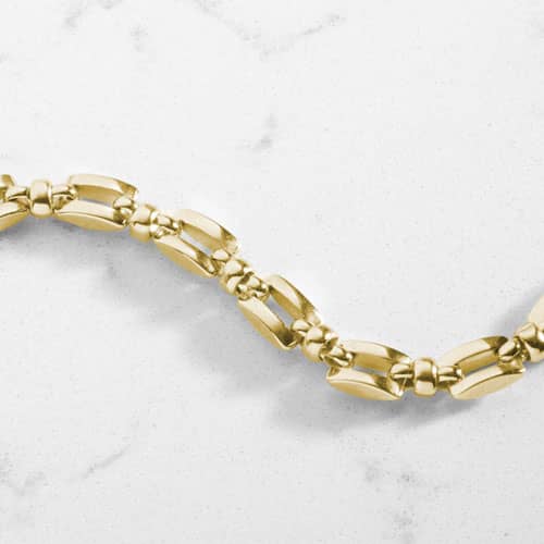 Close-up of the polished geometric links of the gold Hadley bracelet.