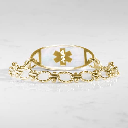 Gold-tone medical ID bracelet featuring textured oval links and a mother-of-pearl alert tag accented with the Star of Life symbol.