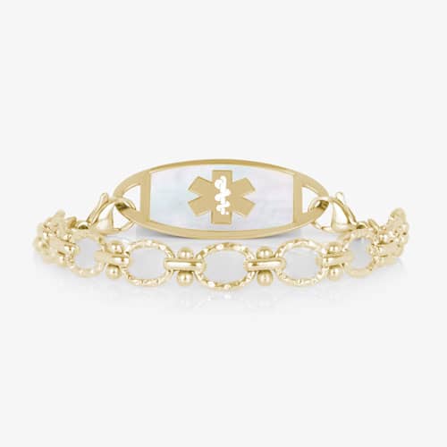 Gold-tone medical alert bracelet with a mother-of-pearl ID tag featuring the Star of Life symbol and elegant textured chain links.