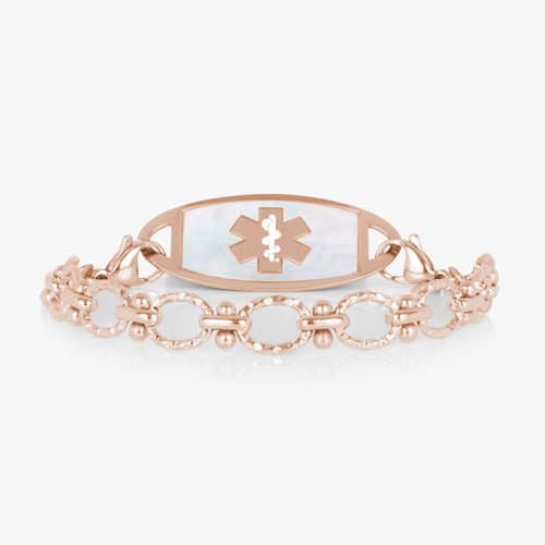 Rose gold medical ID bracelet with textured links and a mother-of-pearl alert tag featuring the Star of Life medical emblem.