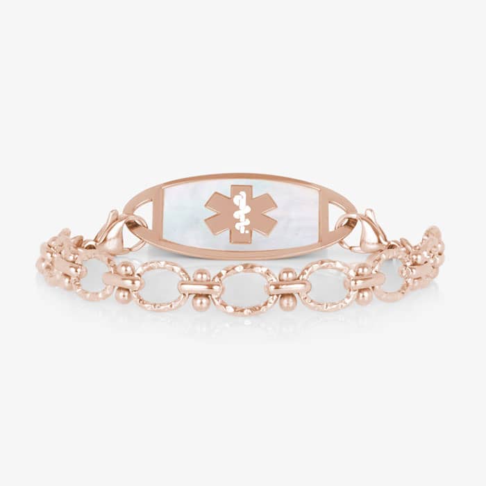 Rose gold medical ID bracelet with textured links and a mother-of-pearl alert tag featuring the Star of Life medical emblem.