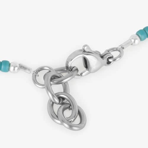 Close-up of the silver-tone lobster clasp and extender chain on the turquoise and white beaded medical ID bracelet.