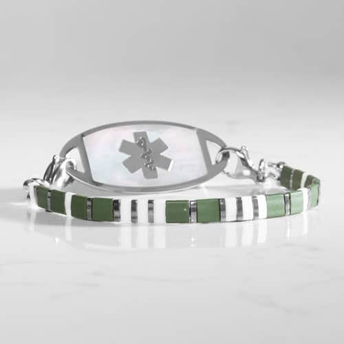 Close-up of an olive green, white, and silver-tone medical ID bracelet paired with a light inlay tag featuring the medical symbol.