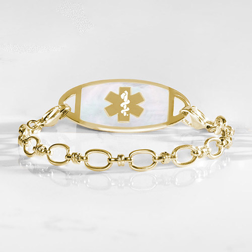 Gold-tone medical ID bracelet with oval-link chain and a white inlay ID tag featuring the medical symbol.