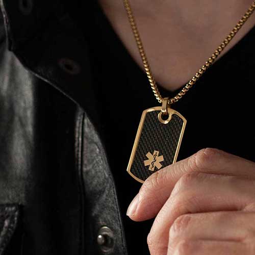 Man wearing gold medical ID alert dog tag necklace with black inlay and gold rolo chain
