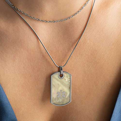 Woman wearing silver and mother of pearl medical ID alert dog tag necklace