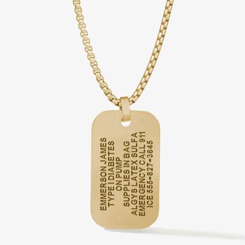 Back of a gold-tone medical ID dog tag engraved with a name, medical conditions, allergies, emergency instructions, and ICE number.