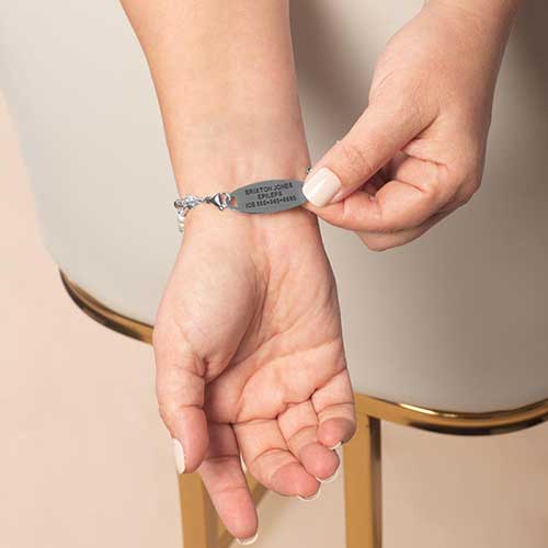 Woman showing custom laser engraved medical ID tag