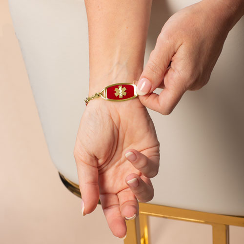 Woman wearing gold tone stainless steel medical ID tag with premium laser engraving.