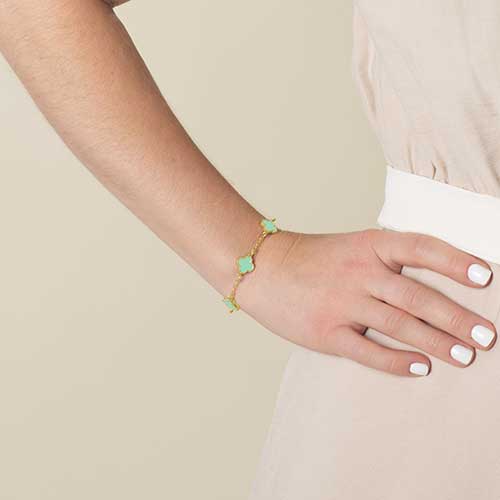 Woman wearing mint green and gold clover shaped chain medical ID bracelet