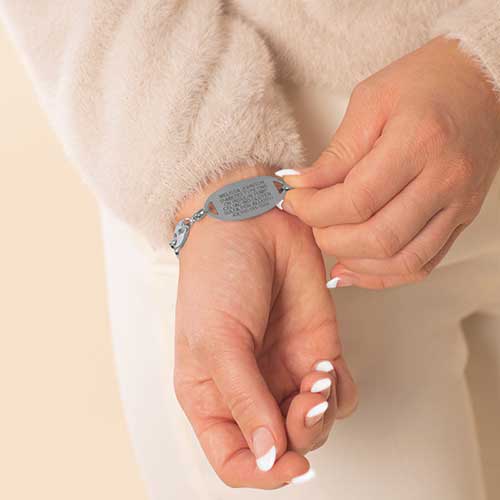 Woman wearing stainless steel medical ID tag with premium laser engraving.