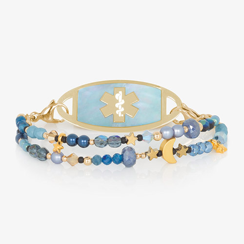 Navy, periwinkle and gold beaded medical ID bracelet with gold tone moon and star charms paired with gold tone stainless steel medical ID tag with blue mother of pearl inlay.