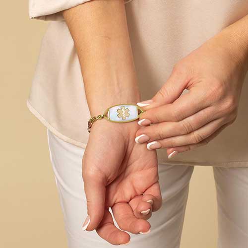 Woman displaying her Gold and Mother of Pearl Medical ID Tag
