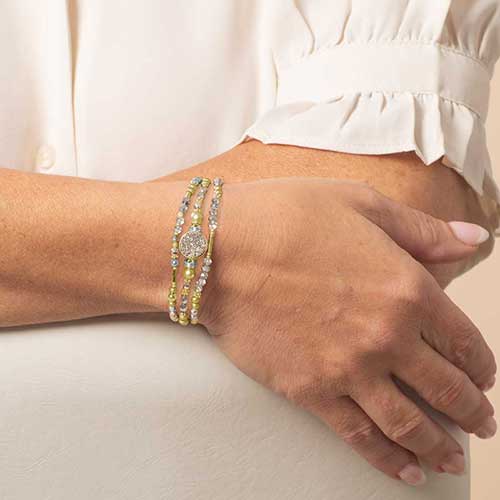 Front view of model wearing two-strand gold and silver medical ID bracelet with beaded detail.