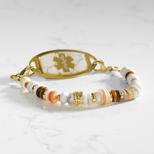 Interchangeable Shelly Stretch Beaded Medical Alert Bracelet featuring natural shell and gold accents, designed for pairing with Lauren’s Hope medical ID tags