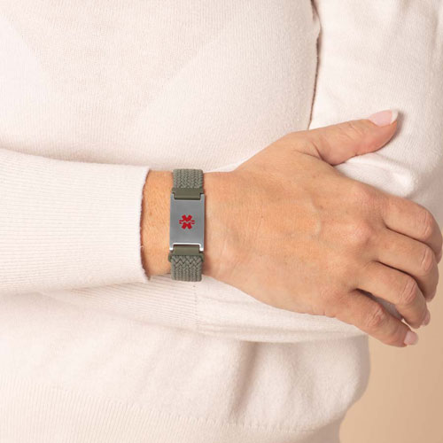 Urban Stretch Medical ID Bracelet in Green and Silver, shown on wrist, featuring a gold medical caduceus symbol for clear medical identification