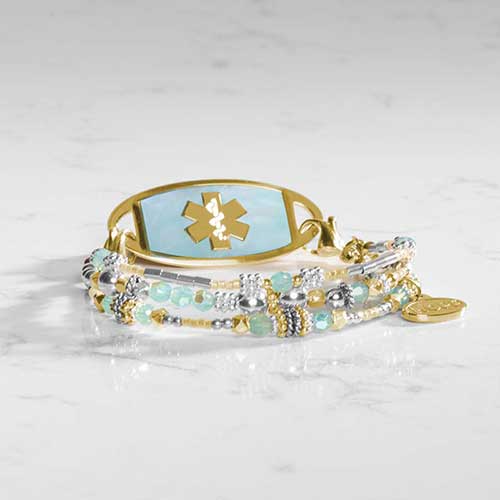 Layflat image of the Rhythm & Blues in Gold bracelet coiled in a circle, highlighting the faceted beads and gold tone ID tag.