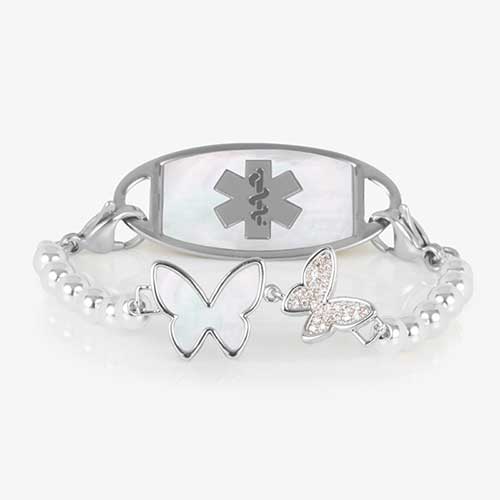 Serenity Stretch Bracelet with silver beads, featuring a double butterfly centerpiece with crystals and mother of pearl inlay, attached to a silver medical ID tag with mother of pearl inlay and silver caduceus.