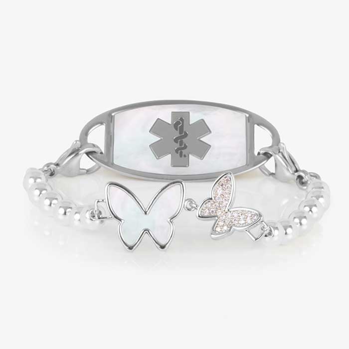 Serenity Stretch Bracelet with silver beads, featuring a double butterfly centerpiece with crystals and mother of pearl inlay, attached to a silver medical ID tag with mother of pearl inlay and silver caduceus.