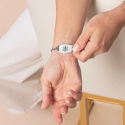 Woman displaying her mother of pearl inlaid medical ID tag.