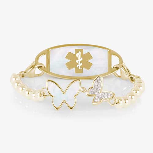 Serenity Stretch medical ID bracelet featuring gold filled beads and adouble butterfly centerpiece adorned with crystal and mother of pearl inlay, attached to a gold medical ID tag featuring mother of pearl inlay and a gold caduceus.
