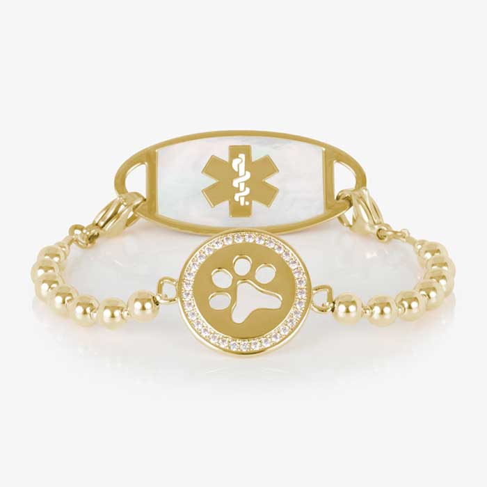 Gold beaded medical ID bracelet with a circular paw print charm accented by clear crystals, shown with a coordinating gold and mother-of-pearl medical ID tag featuring a gold medical symbol.