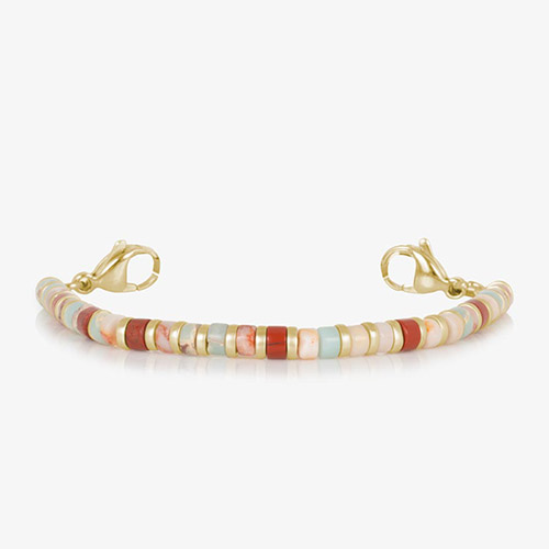 Single-strand gold bracelet made of smooth, round heishi-style beads in a warm mix of natural colors including red, cream, coral, and aqua.