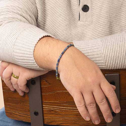 Man wearing denim-blue aventurine beaded medical ID bracelet with gold accents.