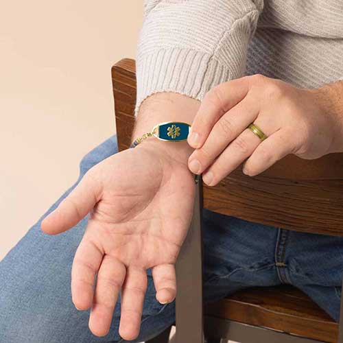 Man displaying his blue inlay, medical alert ID tag.