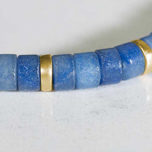 Close up of denim-blue aventurine and gold beads.