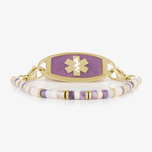 Beaded bracelet featuring gold tone, howlite, and Amethyst beads on a stretch bracelet, attached to a gold tone medical ID with Amethyst inlay and gold tone caduceus medical symbol.