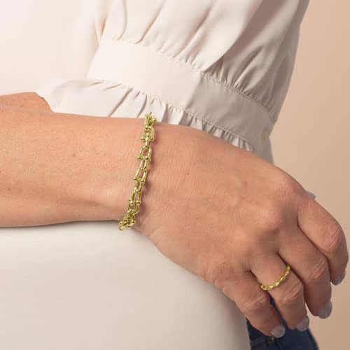 Gold-tone link medical ID bracelet worn on the wrist, showing its polished decorative link design.