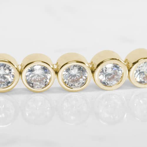 Close-up of Stella Gold bracelet showcasing brilliant clear stones in polished gold-tone bezel settings with radiant sparkle.