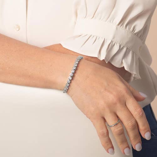 Woman wearing the Stella Silver bracelet, featuring a row of sparkling clear stones in a sleek, elegant interchangeable design.