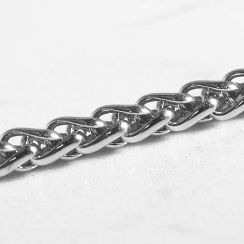 Close-up of the polished interwoven wheat chain links on a silver-tone medical ID bracelet.