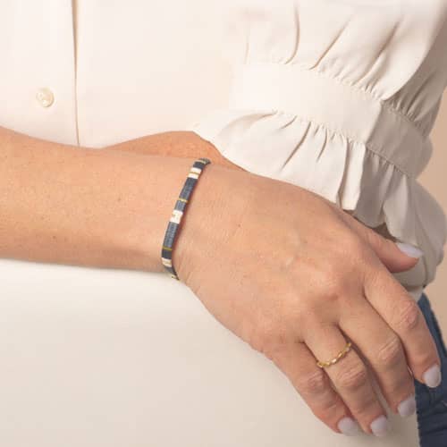 Blue, white, and gold tile bead medical ID bracelet worn on the wrist.