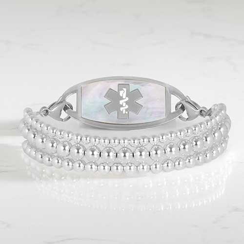 Silver Tilly medical ID bracelet with a mother-of-pearl Star of Life tag and layered beaded strands.
