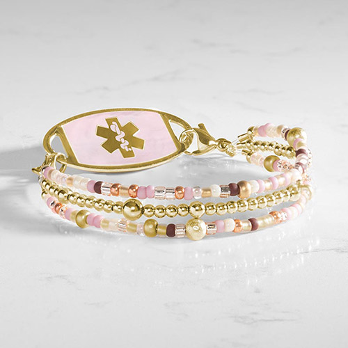 Three-strand beaded medical ID bracelet with gold-tone, pink, cream, and brown accents, shown with a light inlay medical ID tag.